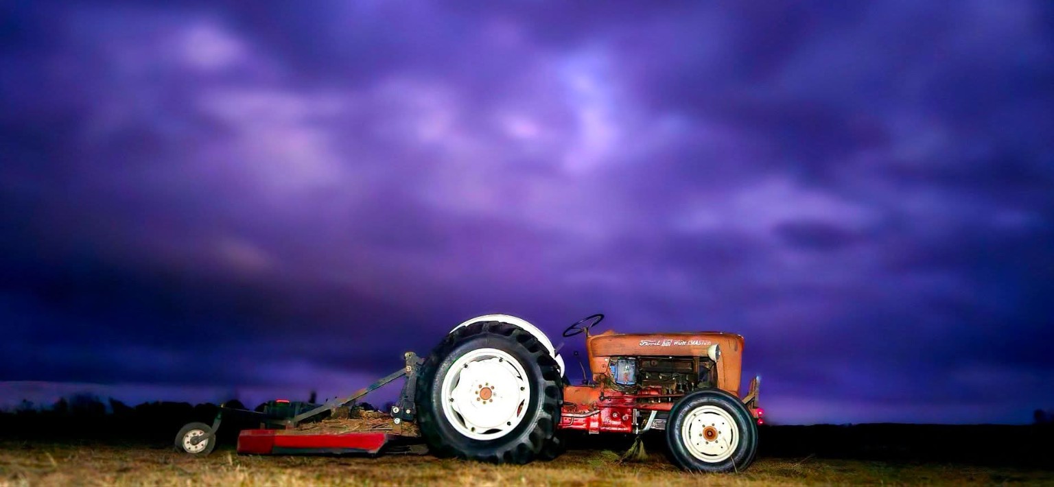 The Ford 601 Workmaster tractor beneath a dramatic purple sky